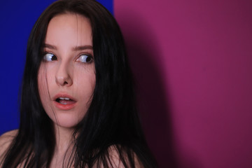 emotional portrait of a brunette girl on a pink-blue background