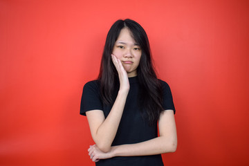 Portrait of Young beautiful asian woman using black T-shirt with red isolated background