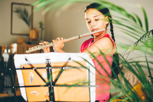 Girl playing the flute at home.