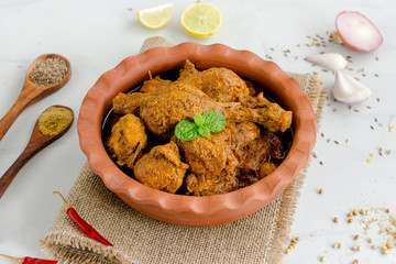Spicy Indian Chicken Curry Garnished with Red Chili Peppers, Cilantro, Onion and Spices