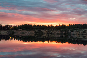 Obraz premium Colorful sunset with a mirror reflection in a forest lake .