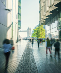 business people, modern buildings and Tower Bridge, London, UK