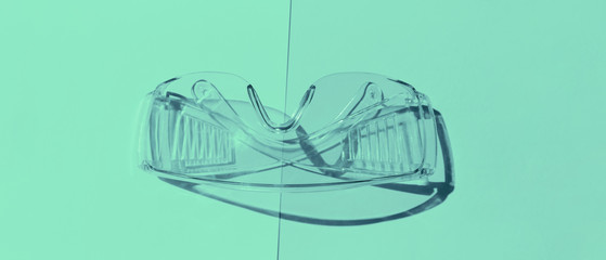 Transparent tinted glasses on mint background. Creative monochrome layout.