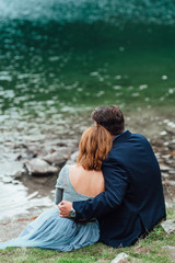 young couple on a walk near the lake surrounded by the mountains