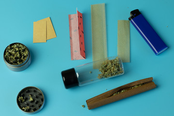 Lighter, smoking paper with filters. Cannabis blunt, marijuana joint and weed in grinder flat lay
