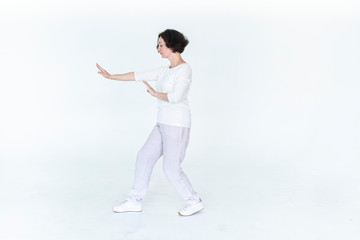 woman practicing qi qong at white studio traditional chinese gymnastics	