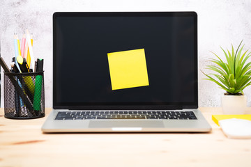 Yellow post-it on the laptop. memo paper on a screen laptop computer. scheduled for job or short note for work concept.
