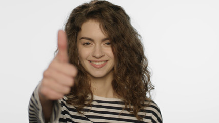 Happy girl showing thumbs up on white background. Young woman showing like sign