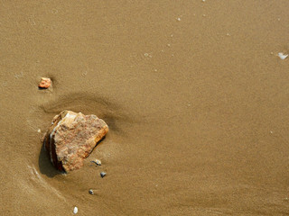 stone on sand beach with wave
