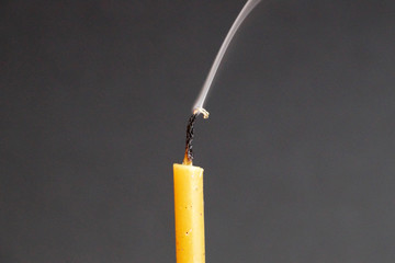 extinguished smoking wax candle on gray background