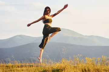 Beautiful young woman doing yoga exercises. Majestic Carpathian Mountains. Beautiful landscape of untouched nature