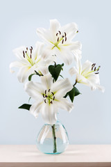 Bouquet beautiful white lilies in vase on the table.