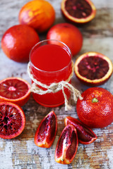 Selective focus. A glass of fresh red orange juice. Red oranges.