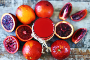 Selective focus. A glass of fresh red orange juice. Red oranges.