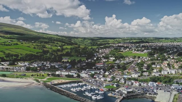 Ballycastle port seascape timelapse aerial view. Yachts, ships, boats on ocean harbor. Cityscape of lodges, cottages, resorts. Irish rural lands. Nature beauty of Ireland. Footage shot in 2K, QHD