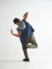 Cool guy breakdancer in hat dancing hip-hop in studio isolated on white background. Break dance...