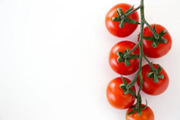 Branch of beautiful juicy organic red cherry tomatoes on white background. Top view of shiny...