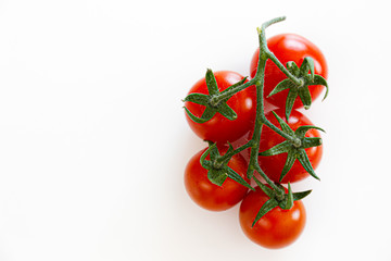Branch of beautiful juicy organic red cherry tomatoes on white background. Top view of shiny...