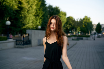 Fototapeta premium fashionable woman on city street in black dress and hat glasses makeup model watch on hand fresh air