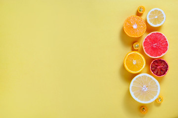 Close up image of juicy organic assorted sliced citrus fruits, visible core texture, bright paper textured background, copy space. Vitamin C loaded food concept. Top view, flat lay.