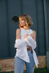 Young beautiful woman wearing fashionable stylish clothes in front of grey monochrome wall.