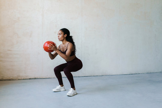Photo of african american woman doing exercise with medicine ball
