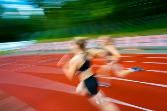 Running woman on sport track, blurred motion abstract background. Sport concept