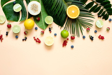 Wet Tropical leaves with fruit and berries on a beige background in pastel colors.