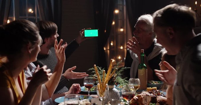 Large positive caucasian family celebrating christmas at home together, having a video chat with friends or relatives using smartphone - celebration, communnication 4k footage