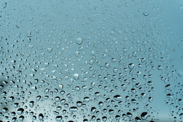 Macro raindrops vapor on window glass. Rain drops on window glasses surface. Through the window view. Drops of rain on glass. Water pattern texture