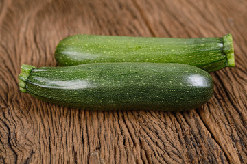 uncooked whole fresh zucchini on wooden background