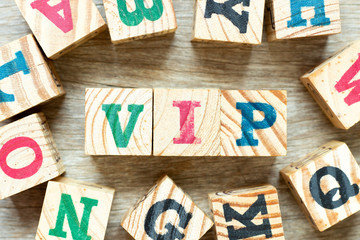 Alphabet letter block in word VIP (abbreviation of very important person) with another on wood...