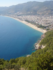 View beach of the Alanya coast from mountain. Boats floats in mediterian sea.