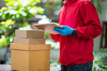 Close up delivery man Wearing blue gloves in red cloth Checking customer boxes for delivery