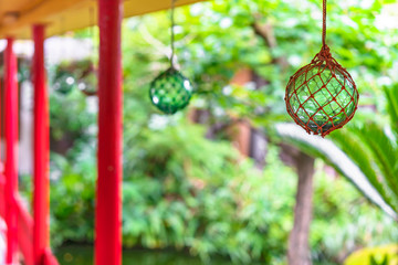 Japanese traditional handmade glass fishing floats Bindama or Ukidama in a nets hanging against a...