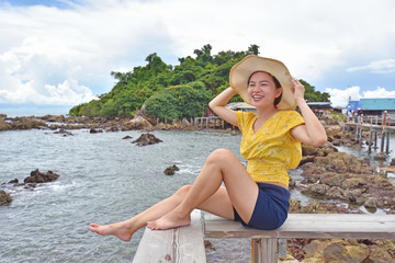 Beautiful Girl in sea style sitting on wooden bridge near the sea.