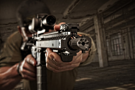 Muzzle View Of A Private Civilian Contractor Working For The Military, Aiming At The Enemy In A Dark Factory.