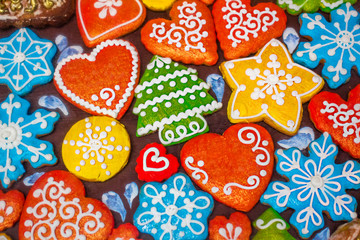 Multicolored gingerbread cookies of different shapes. Christmas food background. Top view. Copy space.