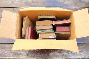 Cardboard box with old books on the table close-up