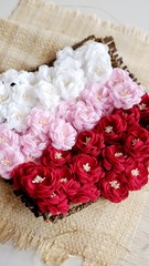 Artificial flowers made out of beautiful fabric texture in red, soft pink, and broken white colors