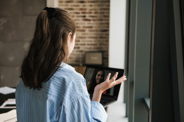 Photo of focused nice girl making video call on laptop
