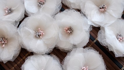Artificial handmade flowers made out of beautiful organza and tulle fabric texture in broken white color