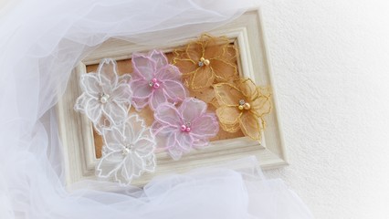 Artificial handmade flowers made out of beautiful organza fabric texture in soft pink, brown, and white colors