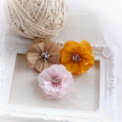 Artificial handmade flowers made out of beautiful fabric texture in soft pink, yellow, and brown color