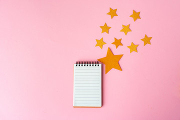 Blank sheet of paper with golden decorative stars. New year resolutions concept