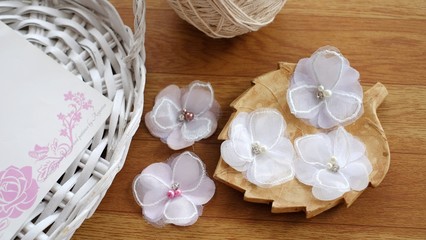 Artificial handmade flowers made out of beautiful organza fabric texture in pastel broken white color