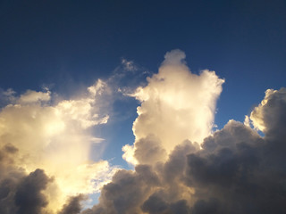 Caribbean fluffy white clouds in tropical bright blue sky at sunset. Tropical white cumulus clouds background.