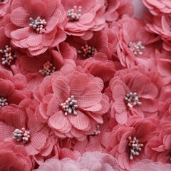 Artificial handmade flowers made out of beautiful fabric texture in pastel salmon pink color