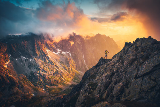 Man on the top of the hill watching wonderful scenery in mountains during summer colorful sunset in High Tatras in Slovakia..
