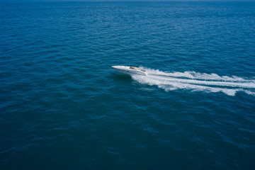 Naklejka na ściany i meble Top view of a white boat sailing to the blue sea. Side view. Motor boat in the sea.Travel - image.